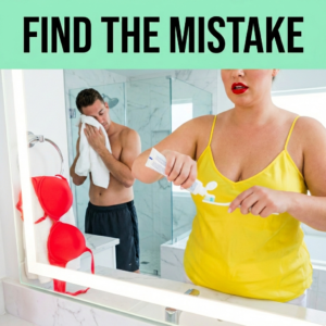 A woman trying to squeeze toothpaste onto a toothbrush in a modern bathroom, but the solid plastic cap is still screwed onto the tube.